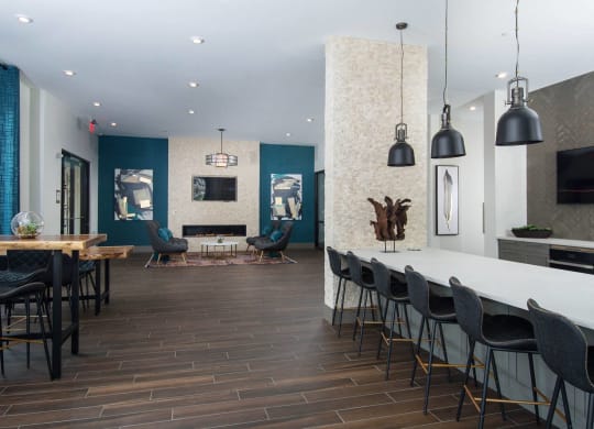 Resident lounge at Alta Clara apartments in Stoneham, MA, featuring counter seating and televisions.