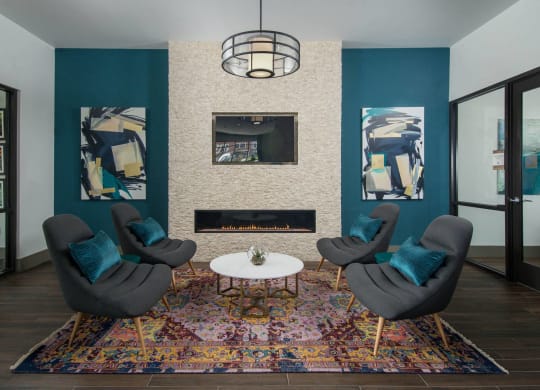 Resident lounge at Alta Clara apartments in Stoneham, MA, featuring wood grain flooring and a fireplace.