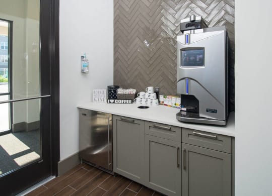a kitchen with a coffee maker and a sink in a hotel room
