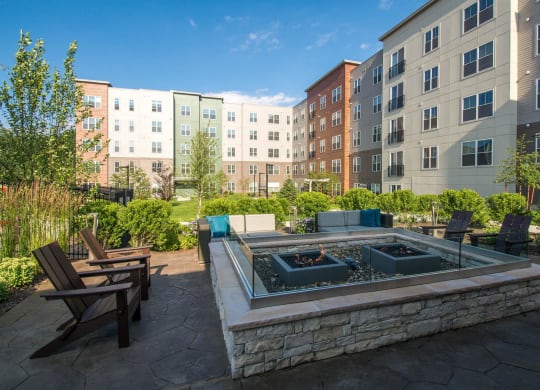 an outdoor patio with a fire pit and an apartment building