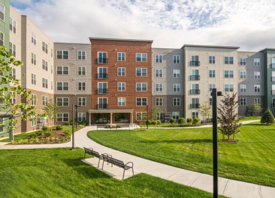 a park with a bench in front of an apartment building