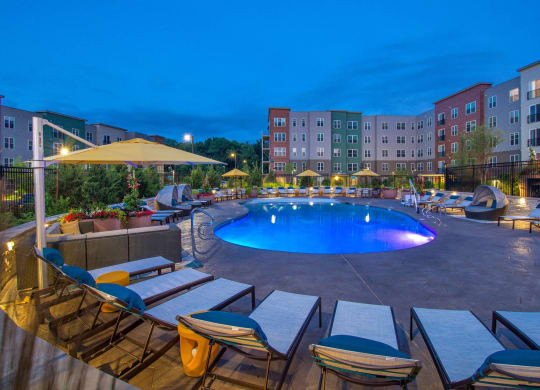a swimming pool at night at an apartment complex