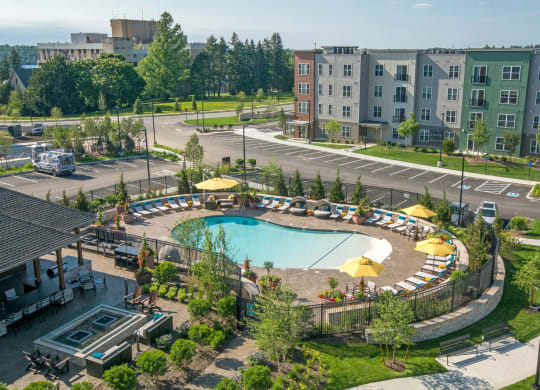 an aerial view of a swimming pool in front of an apartment building