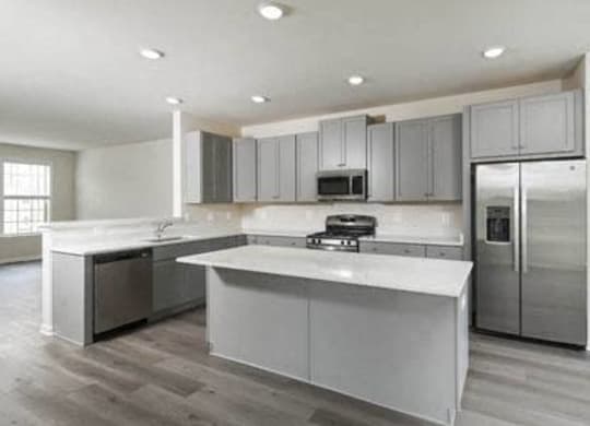 a kitchen with stainless steel appliances and white counter tops