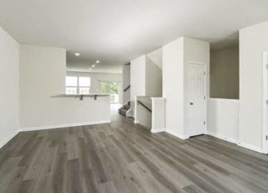 an empty living room with white walls and wooden floors