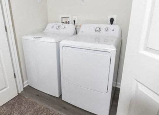 two white washers and dryers in a white room