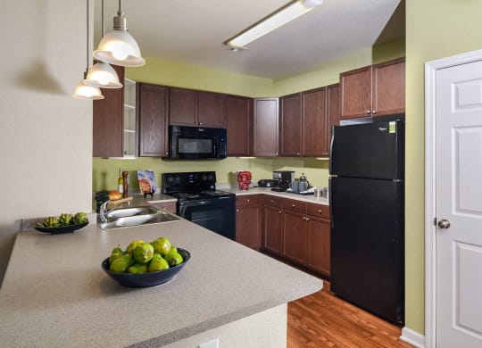 a kitchen with a counter top and a black refrigerator