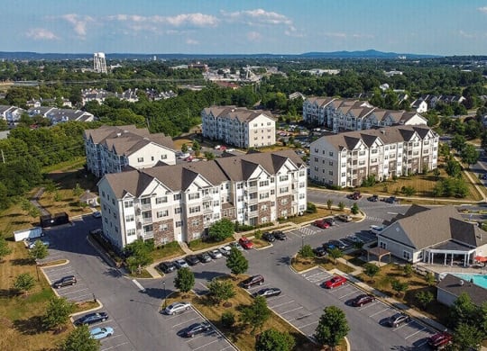 an aerial view of apartment buildings in a parking lot