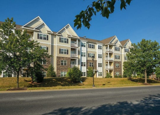 an exterior view of an apartment building on the side of a street