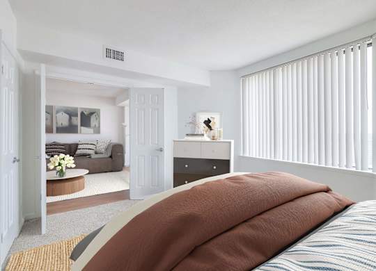 a bedroom with a bed and a living room with a couch