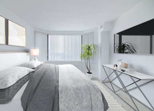 a white bedroom with a bed and a potted plant