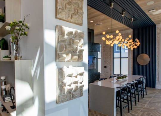 a kitchen and dining room with wood floors and a white wall and a long table