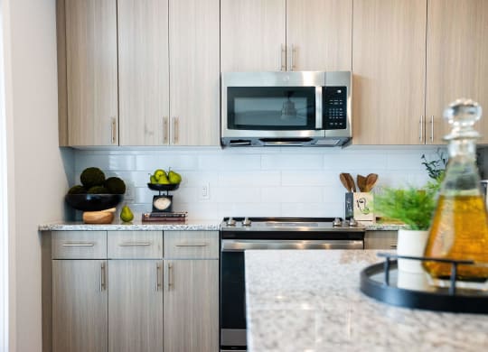 a kitchen with white cabinets and a counter top and a microwave