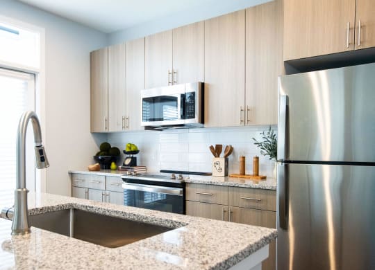 a kitchen with white cabinets and marble counter tops