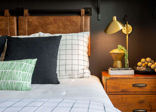 a bedroom with a bed and a nightstand with a lamp and a dresser