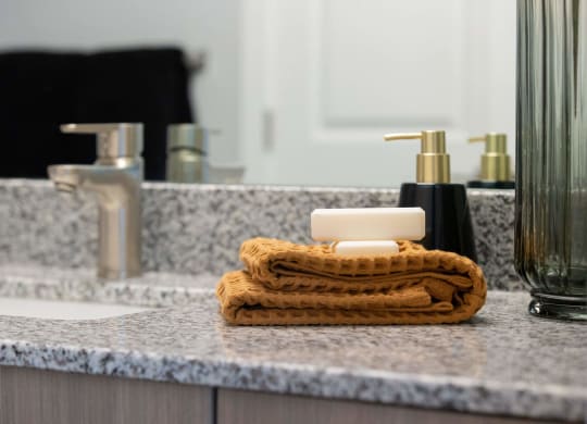 a bathroom with a soap dispenser and a towel on a sink