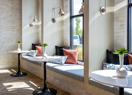 a seating area with tables and windows