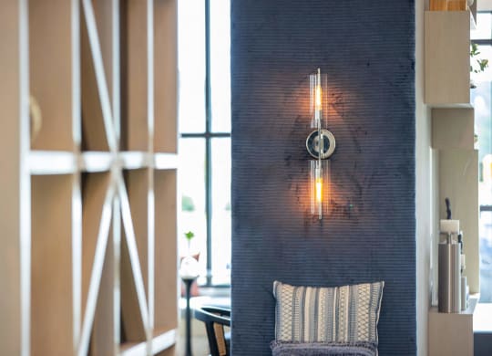a living room with a couch and a light on a brick wall