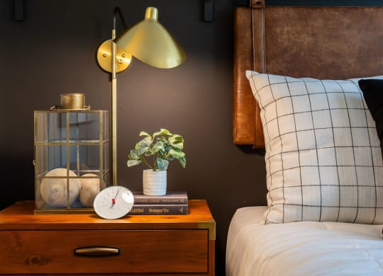a bedroom with a bed and a nightstand with a clock and a lamp