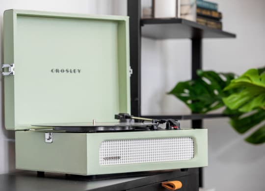 an old radio sitting on a table next to a plant
