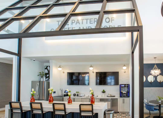 the kitchen and dining area of a glass house