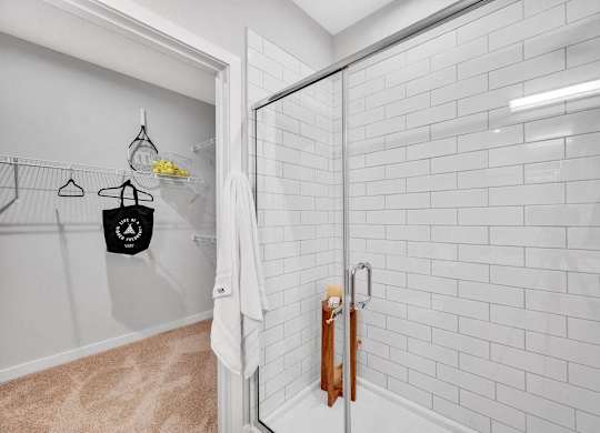 a white bathroom with a shower with a glass door