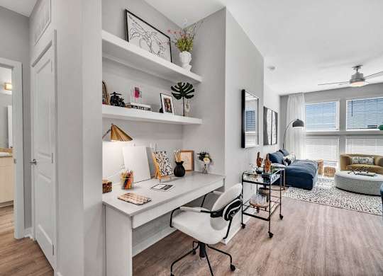 a home office with a desk and a living room