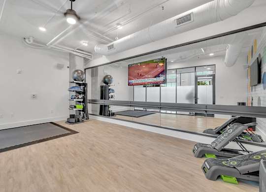 the gym is equipped with treadmills and weights at the flats at west end