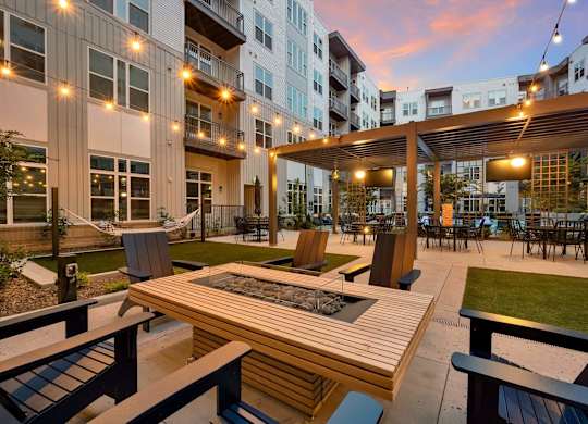 an outdoor patio with tables and chairs at an apartment complex