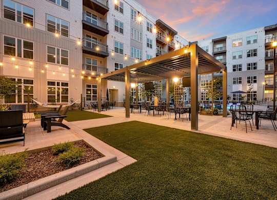 an outdoor patio with tables and chairs at an apartment complex