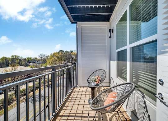 a balcony with two chairs and a view of the ocean