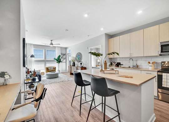 an open kitchen and living room with a bar and stools