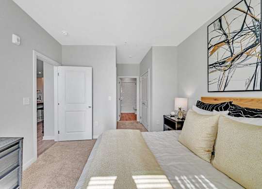 a bedroom with a large bed and a door to a bathroom