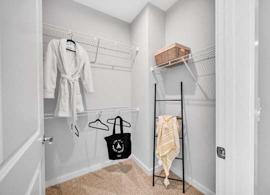 a closet with a rack and clothes hanging on the wall
