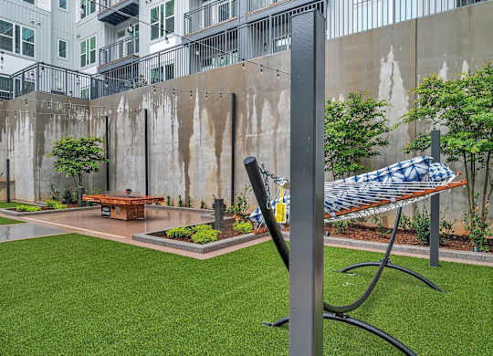 a hammock in a courtyard with a fire pit