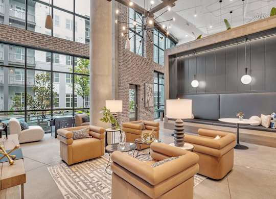 a lobby with couches and chairs and a large wall of windows