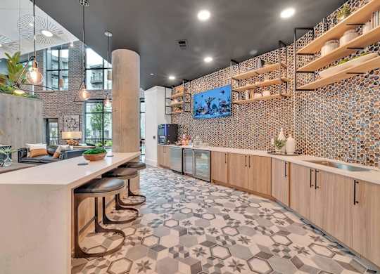 a kitchen with a long counter and stools in a lobby