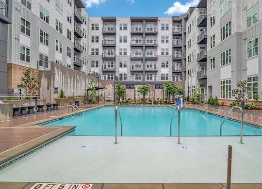 a large swimming pool in front of an apartment building