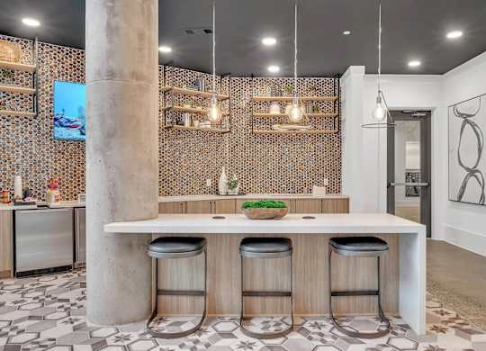 a tasting room with a long counter with black chairs