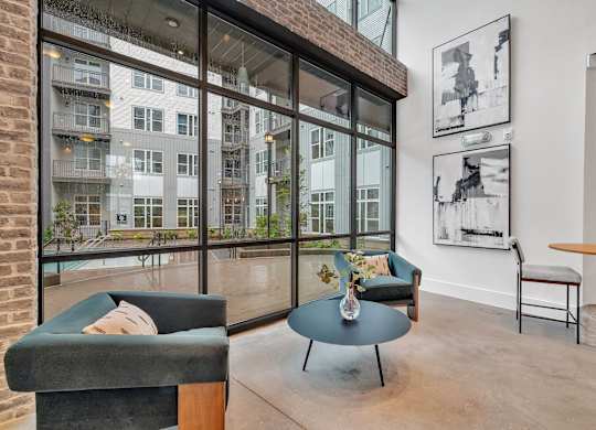 a living room with large windows and a blue coffee table