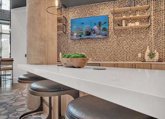 a kitchen with a long white counter and stools