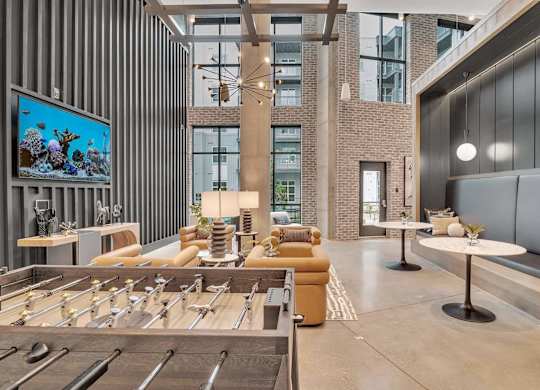 a lobby with couches and tables and a television