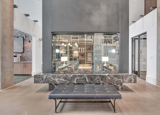 a large glass display case in a lobby with a bench