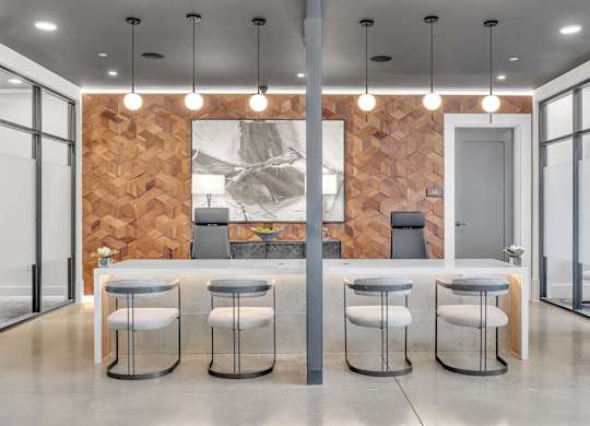 a kitchen and dining area with stools in front of a wood wall