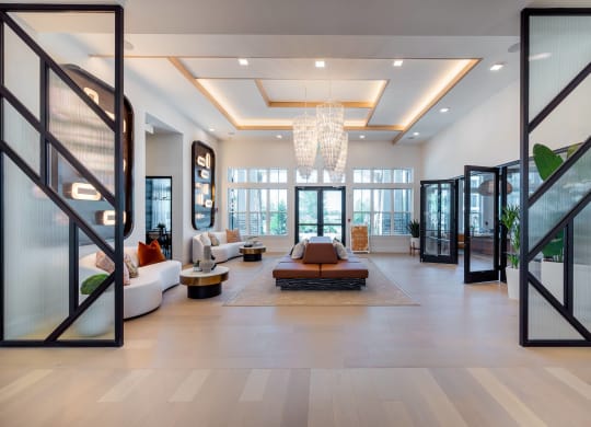 a living room with a couch and a chair and a chandelier