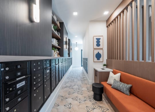 a long hallway with a orange couch and a row of drawers