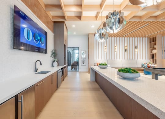 a kitchen with a counter top and a tv on the wall