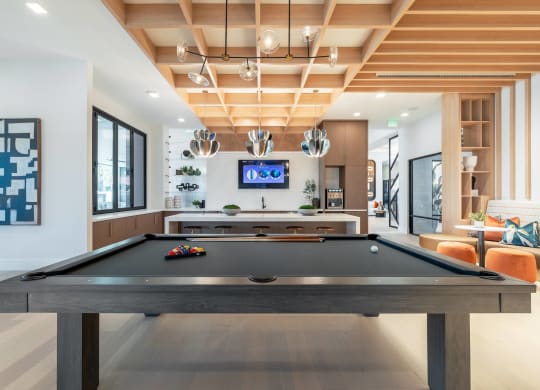 a pool table in the living room of a house with a television