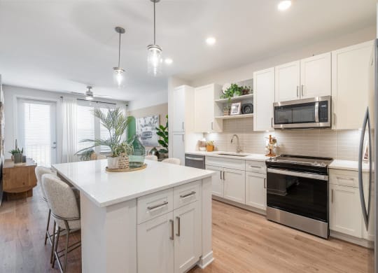 an open kitchen with white cabinets and stainless steel appliances