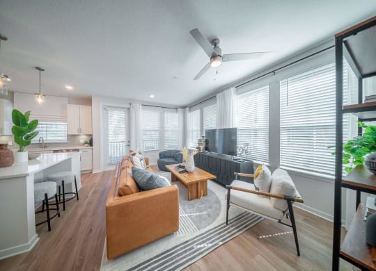 an open living room and kitchen with a ceiling fan